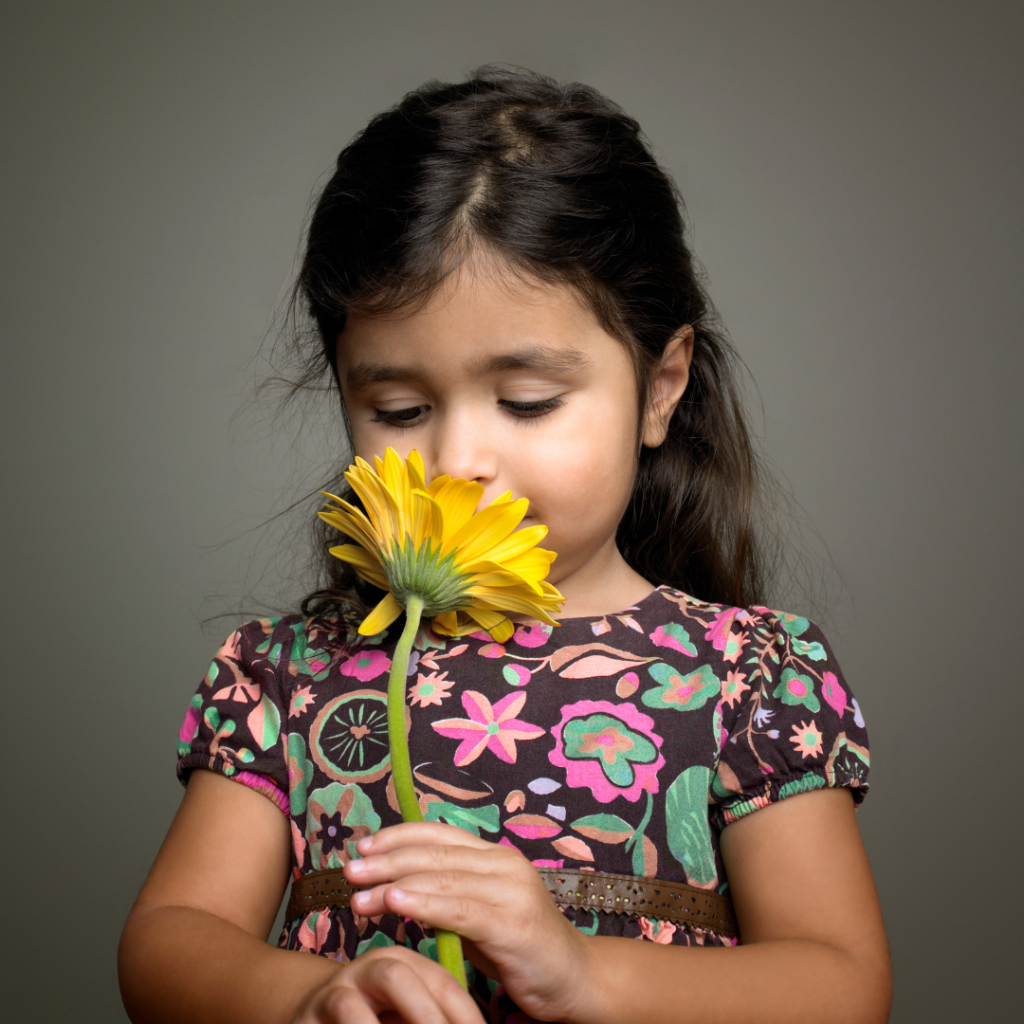 Girl smelling a yellow flower