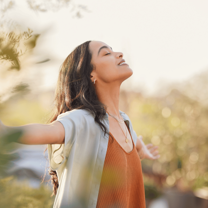 A woman with face tilted toward sky, eyes close. She looks peaceful